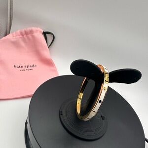NWOT Kate Spade white enamel with gold spades.  Gold  hinged bracelet! With dust